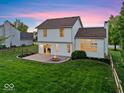 Relaxing backyard with a brick patio, built-in fire pit, green lawn and a partially wooded perimeter at 8835 Harrison Pkwy, Fishers, IN 46038
