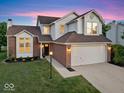 Traditional home with brick and siding, two-car garage, and manicured lawn with tidy landscaping at 8835 Harrison Pkwy, Fishers, IN 46038