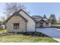 Stunning exterior featuring stone and white painted brick and a well-manicured lawn at 886 J Mccool Way, Greenwood, IN 46142