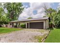 Single-story home with gravel driveway leading to a spacious two-car garage at 11230 N College Ave, Carmel, IN 46032