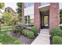 Close-up of a stylish brick home featuring decorative landscaping and a welcoming front entrance at 1311 Central Ave, Indianapolis, IN 46202