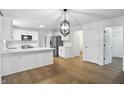 Bright, modern kitchen with stainless steel appliances, white cabinets, and stylish light fixture at 13264 Penneagle Dr, Carmel, IN 46033