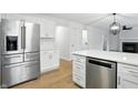 Bright kitchen boasts stainless steel appliances, white cabinets, quartz countertops, and an island at 13264 Penneagle Dr, Carmel, IN 46033