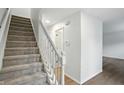 Carpeted stairs with white railing, leading to the upper level of the home with hardwood flooring at 13264 Penneagle Dr, Carmel, IN 46033