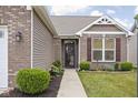 Inviting front entrance with brick accents and manicured landscaping at 1418 Blackthorne S Trl, Plainfield, IN 46168
