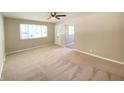 Bright, carpeted living room with a large window and neutral walls, perfect for comfortable living and entertaining at 1605 S Leland Ave, Indianapolis, IN 46203