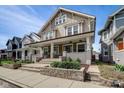Inviting two-story duplex showcasing a charming front porch, complete with seating and tasteful landscaping at 2332 Central Ave, Indianapolis, IN 46205