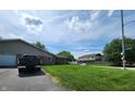 View of the home's driveway, landscaping, and surrounding neighborhood on a sunny day at 3415 Winchester Dr, Indianapolis, IN 46227