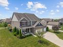 An elevated view showcases this home with a brick facade and a well-maintained front yard at 3679 Woodruff Pl, Bargersville, IN 46106