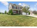 A well-maintained lawn complements this beautiful two-story home with a three-car garage and brick facade at 3679 Woodruff Pl, Bargersville, IN 46106