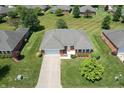 Aerial view of a brick home with a manicured lawn, complemented by lush trees and neighborhood landscaping at 370 Vinewood S Dr, Brownsburg, IN 46112