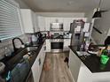 Modern kitchen with white cabinets, stainless steel appliances, and granite countertops at 3836 N Wittfield St, Indianapolis, IN 46235