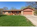 Charming single-story home with well-kept front lawn and a inviting orange front door and access ramp at 40 S Restin Rd, Greenwood, IN 46142