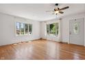 Bright living room featuring hardwood floors, a ceiling fan, and multiple windows at 402 W Clinton St, Danville, IN 46122
