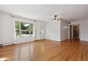 Bright living room featuring hardwood floors, a ceiling fan, and a large window at 402 W Clinton St, Danville, IN 46122