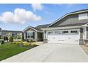 Charming one-story home showcasing stone accents, gray siding, a well-manicured lawn, and a two-car garage at 4182 Hume Ave, Plainfield, IN 46168