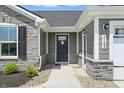 Welcoming front entrance showcasing a stylish gray door, stone accents, and modern exterior lighting at 4182 Hume Ave, Plainfield, IN 46168
