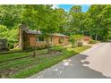 A charming single-story home features a stone chimney, wood siding, and a quaint wooden fence at 5052 Helmsburg School Rd, Morgantown, IN 46160