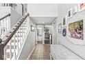 Inviting hallway with staircase, neutral tones, tile flooring and decorative wall art leading into the living spaces at 5299 Breakers Way, Carmel, IN 46033