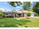 Charming single-story home features a well-manicured lawn, neutral siding, and cozy front porch at 5672 W New York St, Indianapolis, IN 46224
