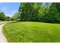 Expansive, well-maintained front yard, showcasing lush green grass and mature trees, providing curb appeal at 5720 Hickory Hollow Dr, Plainfield, IN 46168