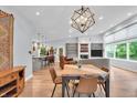 Open-concept living room with dining area, hardwood floors, fireplace, and large windows at 5903 Birchwood Ave, Indianapolis, IN 46220
