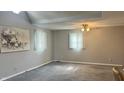The room has high ceilings, a ceiling fan, carpet flooring, and two windows for plenty of light at 6408 W Taylor Rd, Muncie, IN 47304