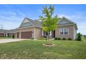 Beautiful brick home with a well-maintained lawn and a young tree in the front yard at 6420 Colt Ln, Anderson, IN 46013