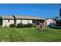 Well-kept home with a neat front yard, tidy landscaping, and a welcoming front porch adorned with American flags at 6550 Reed Rd, Pittsboro, IN 46167
