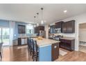 Modern kitchen featuring a large island with granite countertops, stainless steel appliances, and dark wood cabinetry at 6589 Kara Ln, Brownsburg, IN 46112
