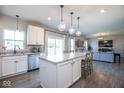 Bright kitchen featuring a center island with counter seating, stainless steel appliances and open access to living room at 7128 Verwood Ct, Plainfield, IN 46168