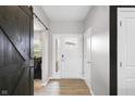 Welcoming foyer with wood-look flooring, a white front door, and a barn door, creating a bright and modern entrance at 757 Carson Ln, Greenfield, IN 46140