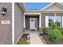 Inviting front porch with white columns, brick accents, and a well-manicured garden at 757 Carson Ln, Greenfield, IN 46140