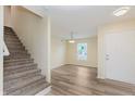 Bright entryway featuring wood-look floors, staircase, and a view to the living area through a large window at 8248 Ossian Ct, Camby, IN 46113