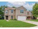 Two-story home with a two car garage, brick accents, well-kept lawn, and neutral colored siding at 8248 Ossian Ct, Camby, IN 46113