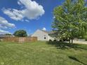 Large grassy yard with a privacy fence and a mature tree at 8460 Ferguson Cir, Avon, IN 46123