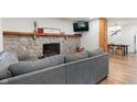 Cozy living room featuring a stone fireplace, hardwood floors, and a comfortable gray sofa at 11315 House St, Indianapolis, IN 46259