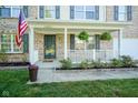 Inviting front porch with hanging plants and tasteful landscaping at 12847 Arvada Pl, Fishers, IN 46038