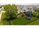Expansive backyard showcasing a well-maintained lawn, mature trees, a patio area, and a trampoline at 12998 Silbury Hill Way, Fishers, IN 46037