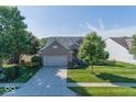 Beautiful brick home with a spacious driveway and lush green lawn under a clear blue sky at 13161 Duval Dr, Fishers, IN 46037