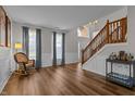 Inviting living room with hardwood floors, rocking chair, and open access to the foyer and stairway at 1319 Gable Lake Dr, Brownsburg, IN 46112