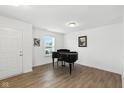 Bright living room with wood floors, a black piano, natural light, and neutral-colored walls at 1338 Delacorte Cir, Shelbyville, IN 46176