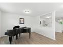 Bright living room with wood floors, a black piano, natural light, and neutral-colored walls at 1338 Delacorte Cir, Shelbyville, IN 46176