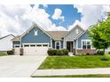 Inviting home showcasing blue siding, brick accents, a manicured lawn, and an attached two-car garage at 19009 Beverly Shones Ln, Noblesville, IN 46062