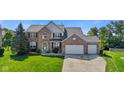 Charming two-story brick home with a well-manicured lawn and a spacious three-car garage at 2096 Whitetail Ct, Avon, IN 46123