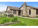Charming ranch home featuring a stone chimney and a garden in a well-manicured front yard at 2303 Alexandria Dr, Greenfield, IN 46140