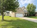 Lovely two-story home with a two-car garage, brick accents, and a well-maintained lawn and landscaping at 2444 Cole Branch Ct, Indianapolis, IN 46239