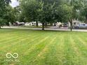 Spacious, fenced backyard with mature trees, perfect for outdoor activities at 2650 Woodrow Ave, Indianapolis, IN 46241