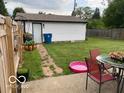 Backyard with a detached garage, patio with outdoor seating, and ample green space at 2650 Woodrow Ave, Indianapolis, IN 46241