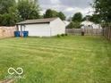 Large backyard with lush green grass and a wood fence, offering privacy at 2650 Woodrow Ave, Indianapolis, IN 46241